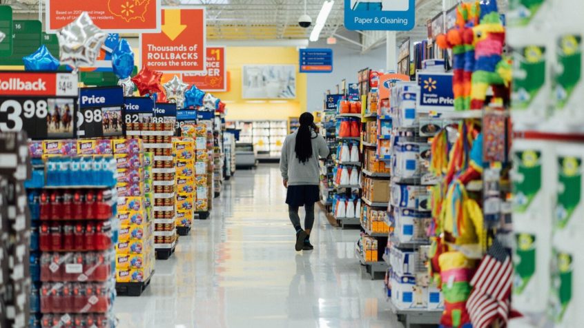 Woman walking down a bulk grocery aisle for roadrunner foodbank